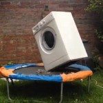 Wasmachine met baksteen op trampoline