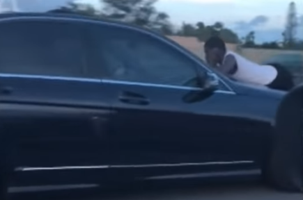 OMG! Vrouw heeft ruzie met haar vent en verlaat de motorkap van auto niet