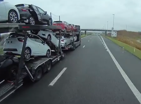 Illegale migranten liften mee op oplegger met nieuwe auto´s