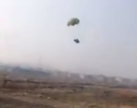 Kip met parachute kukkelt naar beneden uit vliegtuig