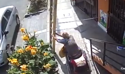 Man in rolstoel trekt trap met schilder omver